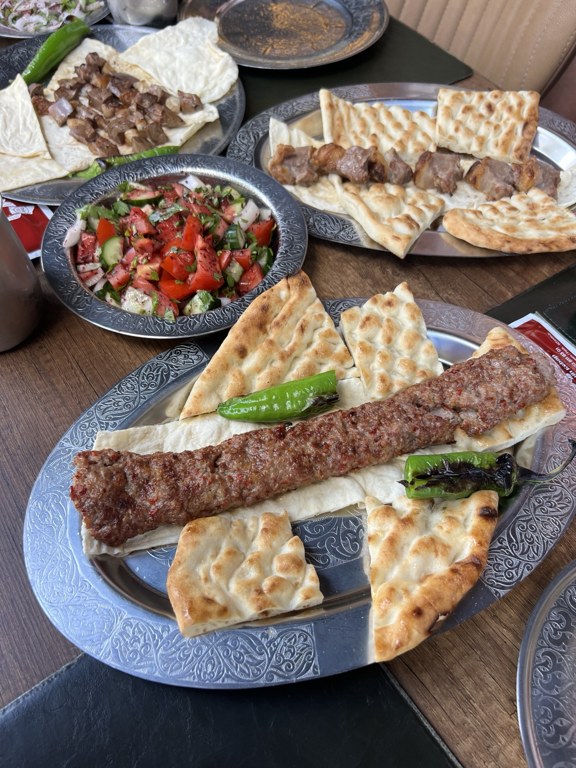 Adana kebabı, tırnak pide, köz biber ve salatayla kurulan sofra