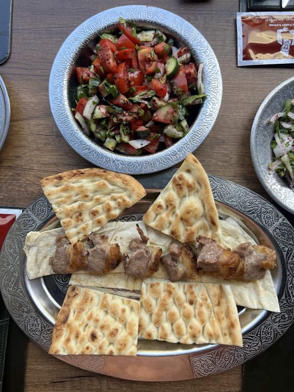 Tırnak pide üzerinde et şiş ve yanında tablacı salatası