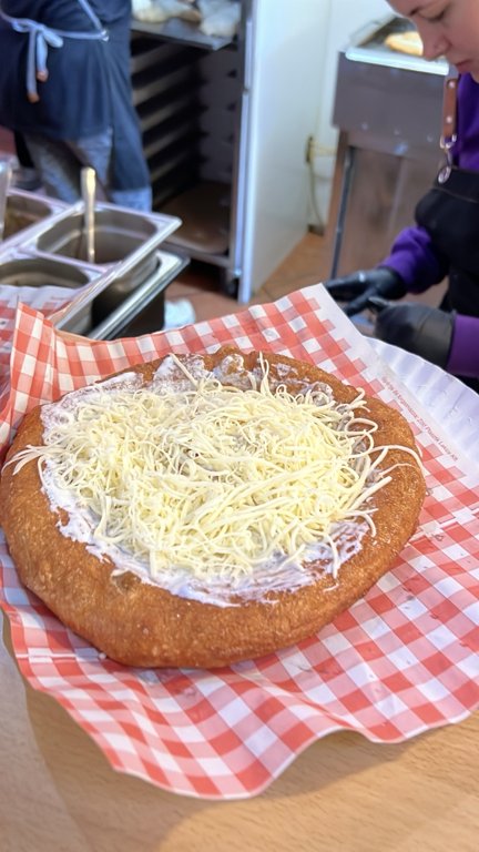 Tezgahta hazırlanan ekşi kremalı ve rendelenmiş peynirli klasik lángos