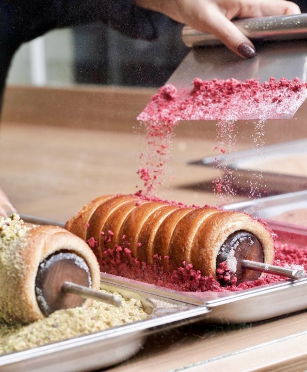 Kürtissimo’da kalıp üzerindeki chimney cake’e kırmızı kaplama serpilmesi