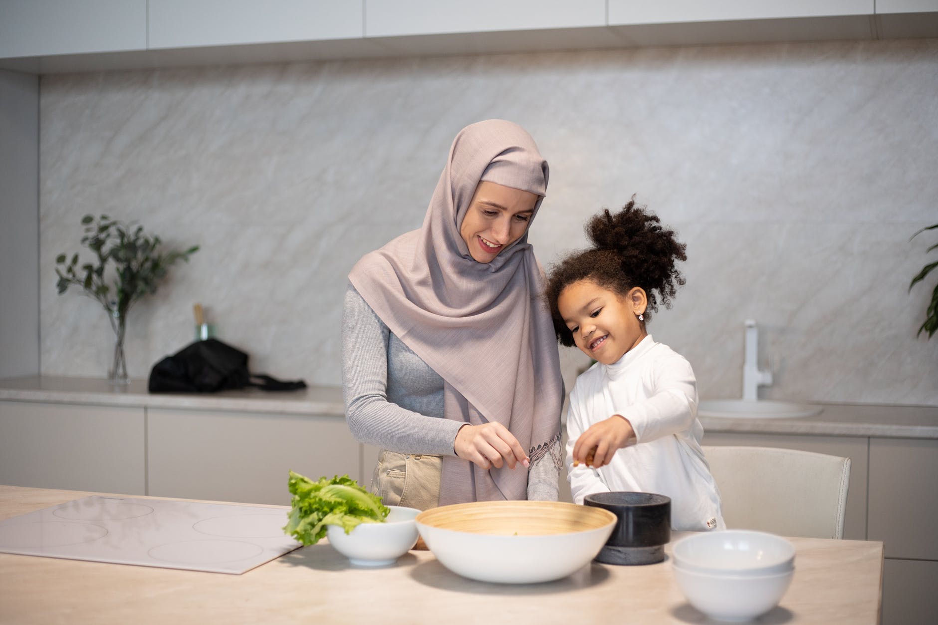 happy diverse mother and daughter cooking together