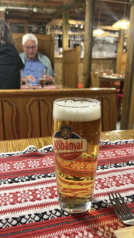 Pipa Étterem’in ahşap masasında Kőbányai bardağı