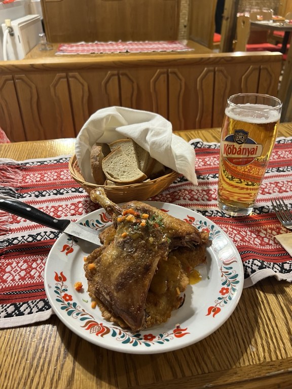 Pipa Étterem’de ördek tabağı, ekmek sepeti ve Kőbányai bulunan sofra